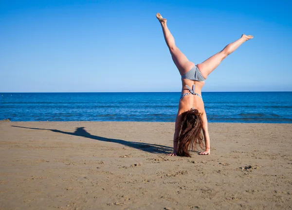 Vrouw springen op het strand genieten van de zomervakantie — Stockfoto