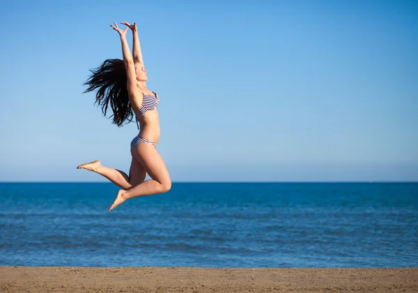 Kobieta, skoki na plaży, ciesząc się letnie wakacje — Zdjęcie stockowe