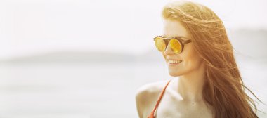 Sahilde sıcak yaz güneş ışığı genç kadın