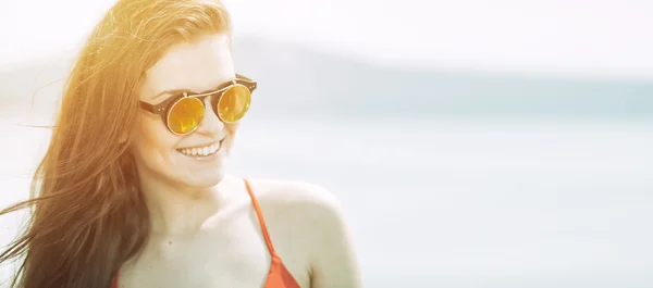 Jeune femme sur la plage dans la lumière chaude du soleil d'été — Photo