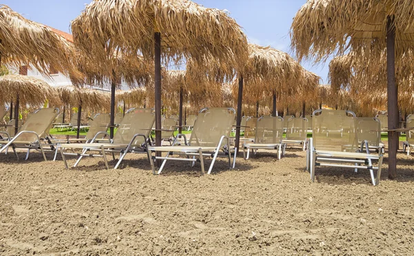 Tumbonas vacías en la playa antes de la temporada de verano — Foto de Stock