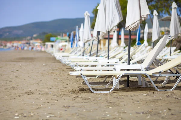 Empty sun loungers on the beach before summer season — Stock Photo, Image