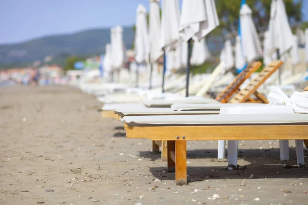 在之前的夏季海滩上的空日光躺椅 — 图库照片