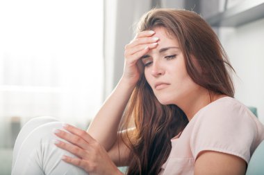 Evde kanepede yalan baş ağrısı olan kadın. rahat tarzı kapalı ateş