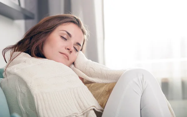 Mujer joven acostada en el sofá y durmiendo en casa. Estilo casual sesión de interior —  Fotos de Stock