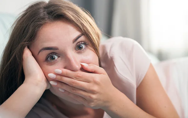 Wanita muda berbaring di sofa dan dia terkejut. Casual gaya menembak dalam ruangan — Stok Foto