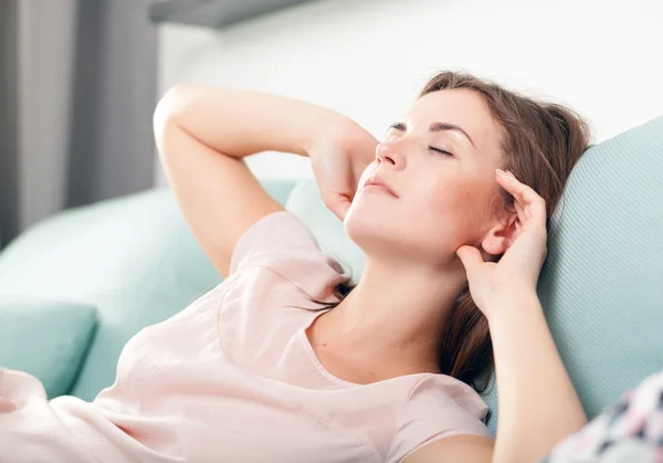Sleepy young woman lying on couch and relaxing at home. Casual style indoor shoot — Stock Photo, Image