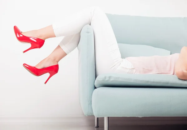 自宅のソファでリラックスした女性と赤いハイヒール — ストック写真