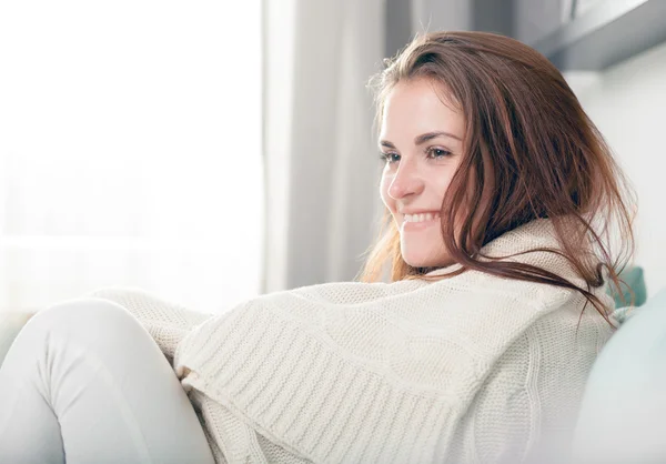 Glad ung kvinna liggande på soffan och koppla av hemma. Avslappnad stil inomhus skott — Stockfoto