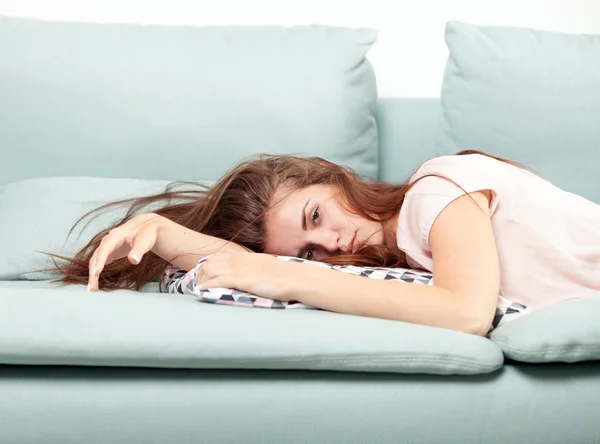 Lelah wanita muda berbaring di sofa di rumah. Casual gaya menembak dalam ruangan — Stok Foto