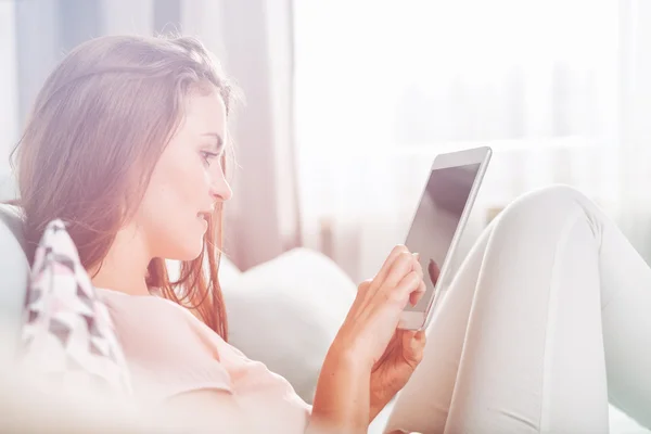 Jonge vrouw zittend op de Bank thuis met tablet pc. Casua — Stockfoto