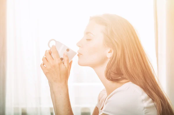 Porträtt av ung kvinna kopplar av hemma och dricker kaffe. Ca — Stockfoto