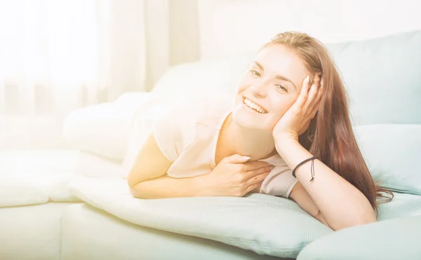 Happy young woman lying on couch and relaxing at home. Casual st — Stock Photo, Image