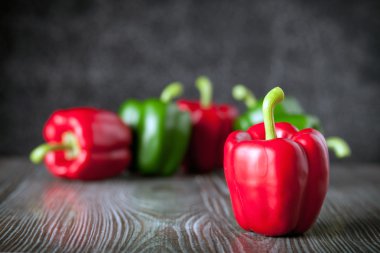 Ahşap tahtası koyu arka plan kopya alanı üzerinde kırmızı ve yeşil biber