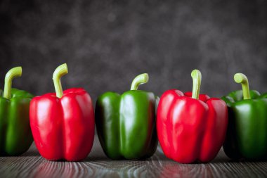 Ahşap tahtası koyu arka plan kopya alanı üzerinde kırmızı ve yeşil biber