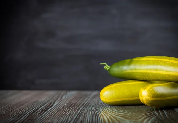 Pepino na mesa de madeira espaço de cópia de fundo escuro — Fotografia de Stock