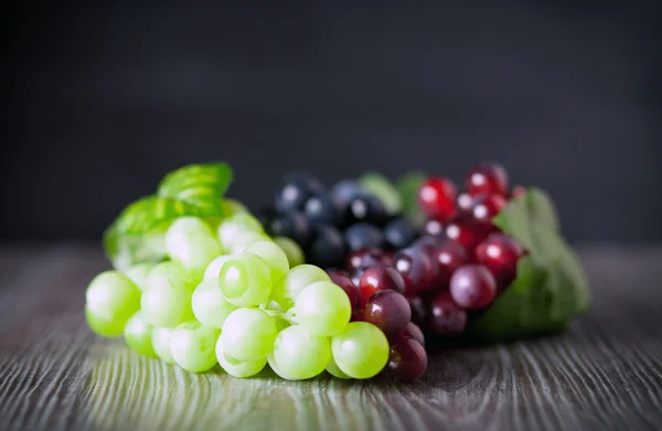 Kolorowe winogron na płycie ciemnym tle kopii przestrzeni — Zdjęcie stockowe