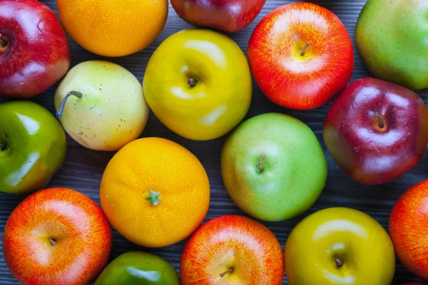 Reife Äpfel Birnen und Orangen auf Holzbrett Hintergrund — Stockfoto