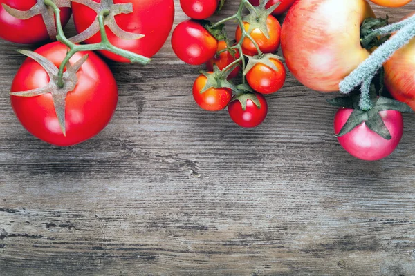 Tomates maduros frescos no fundo da placa de madeira, espaço de cópia — Fotografia de Stock