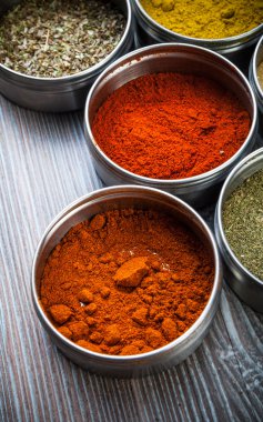 Baharatlar ve otlar ahşap masa üzerinde metal konteynerler