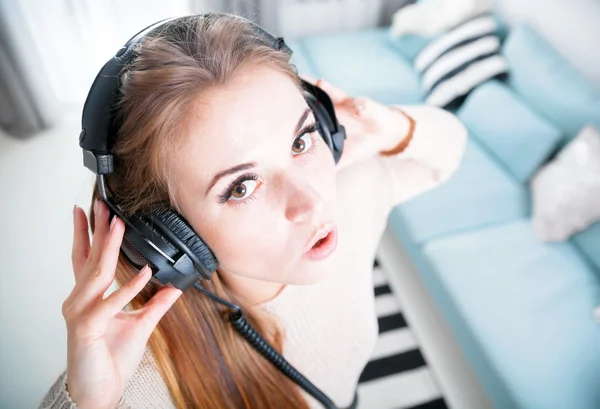 Портрет молодой женщины с наушниками, слушающей музыку дома — стоковое фото