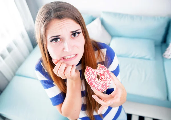 Femme au régime attrapé pendant qu'elle mange un beignet — Photo