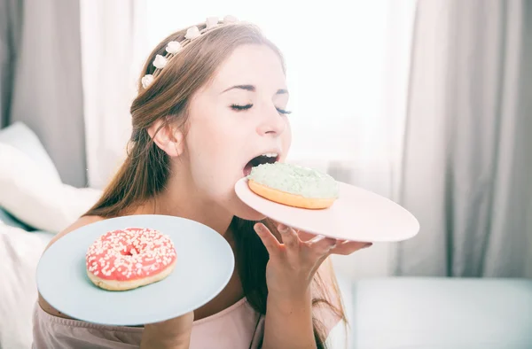 Mulher olhar como princesa em casa com dois donuts — Fotografia de Stock