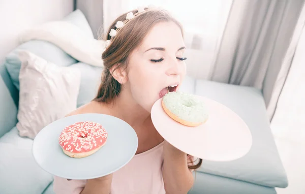 Mulher olhar como princesa em casa com dois donuts — Fotografia de Stock