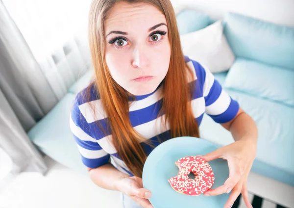 Kobieta złowionych podczas jedzenia pączek w diecie — Zdjęcie stockowe