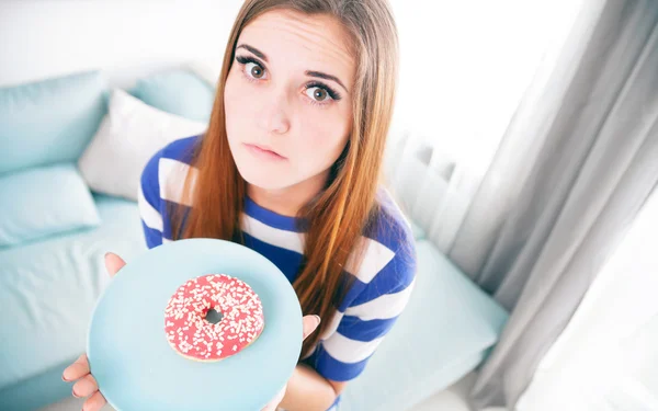 Woman on diet with donut thinking about eating it — Stock Photo, Image