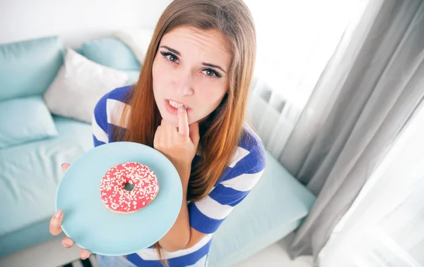 Mulher em dieta com donut pensando em comê-lo — Fotografia de Stock
