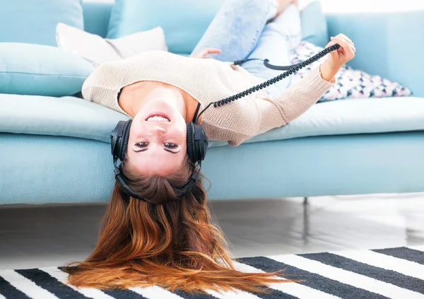 Frau mit Kopfhörer liegt und hört zu Hause Musik — Stockfoto
