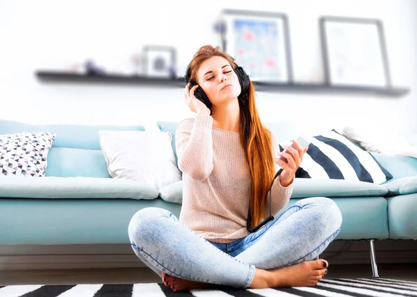 Женщина в наушниках слушает музыку дома — стоковое фото