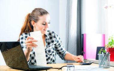 Hesaplama ve ev ofis içinde fatura ödeme gülümseyen kadın