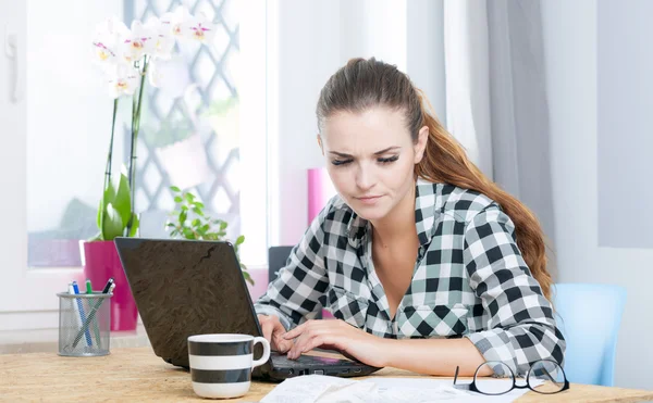 Молодая женщина работает в домашнем офисе с помощью ноутбука — стоковое фото
