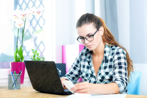 Mulher em óculos trabalhando no escritório em casa usando laptop — Fotografia de Stock
