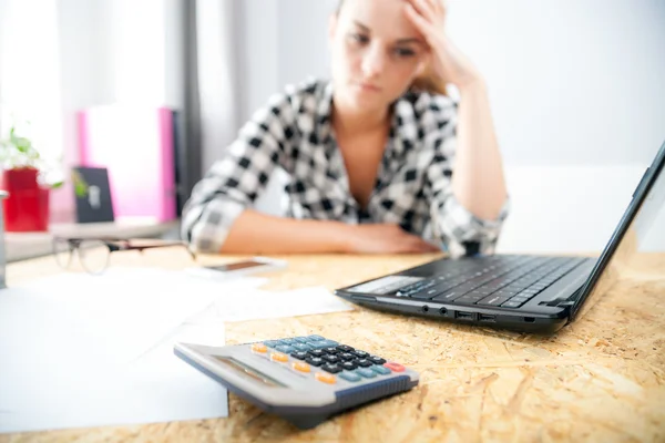 Stressed and depressed woman in home office calculating bills — Stock Photo, Image