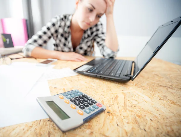 Stressed and depressed woman in home office calculating bills — Stock Photo, Image