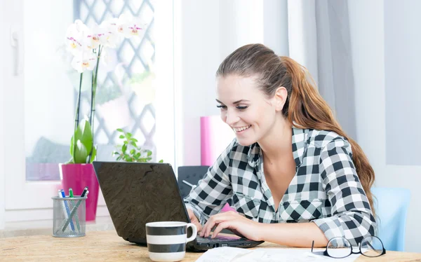 Jovem feliz trabalhando no escritório em casa usando laptop — Fotografia de Stock
