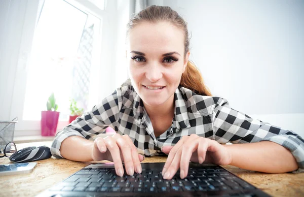 Usmívající se žena pomocí přenosného počítače v domácí kanceláři, pohled z webové kamery — Stock fotografie