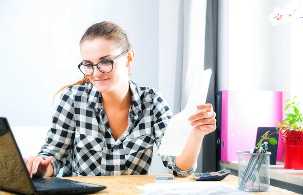 Uśmiechnięta kobieta, kalkulując i płacąc rachunki w domowym biurze — Zdjęcie stockowe