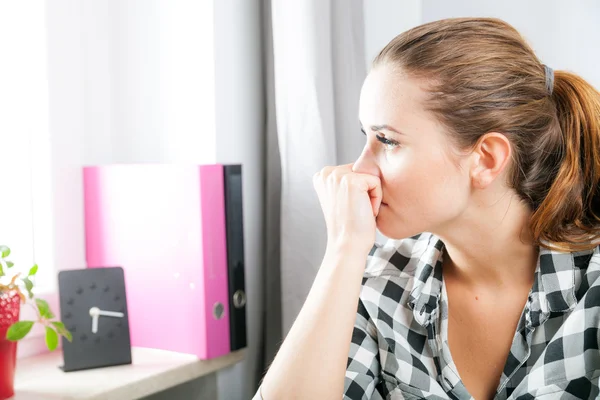 Desperate and worried woman in home office looking at window — Stock Photo, Image