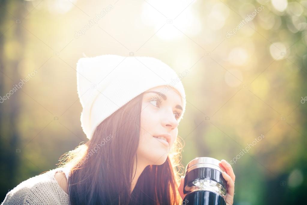 Woman with thermos outdoor portrait in sunny daylight
