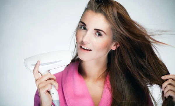 Свіжа дівчина сушить довге волосся сушаркою — стокове фото