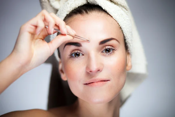 Fresh model girl shaping eyebrows with tweezer — Stock Photo, Image