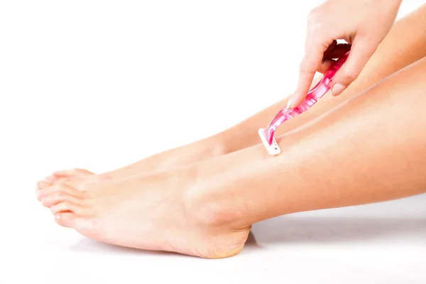 Mujer delgada piernas de afeitar con afeitadora —  Fotos de Stock