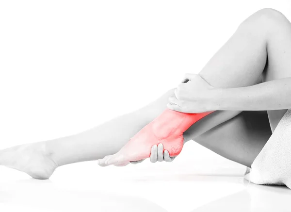 Woman massaging her painful ankle — Stock Photo, Image