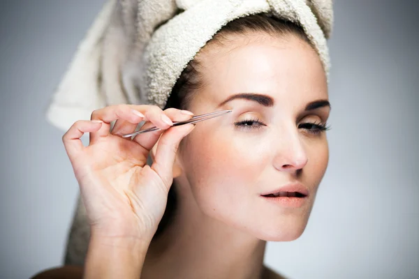 Fresh model girl shaping eyebrows with tweezer — Stock Photo, Image