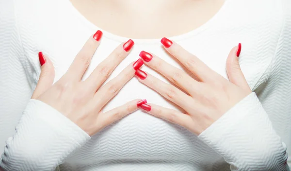 Женщина показывает свои красные ногти, маникюр — стоковое фото