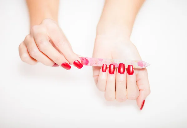 Girl hand manicure with nail file on bright background — Stock Photo, Image